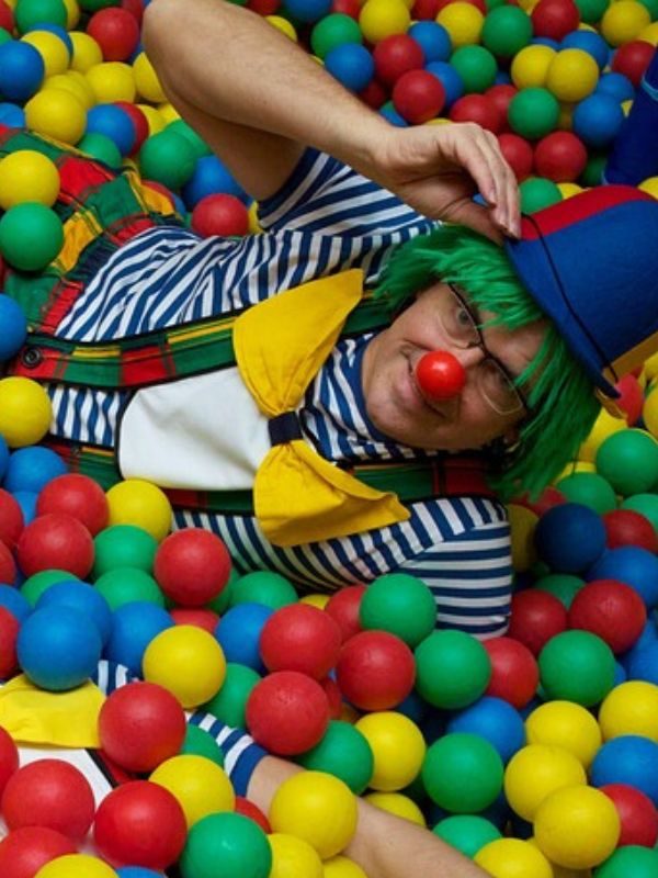 clown dans une piscine à boule et qui sourit