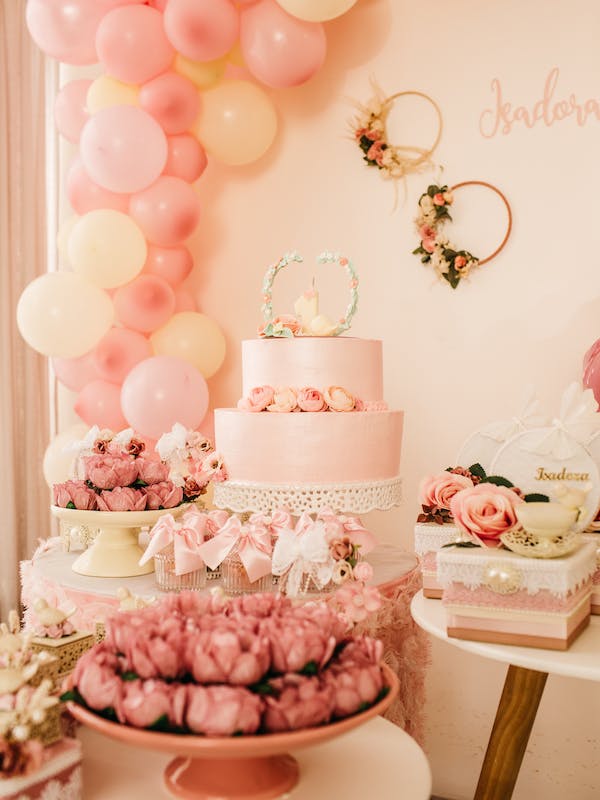 décoration rose avec une arche de ballon et des migniardises