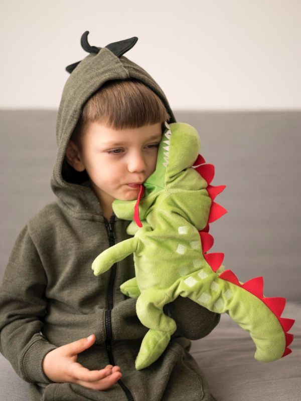 petit garçon avec une peluche dragon