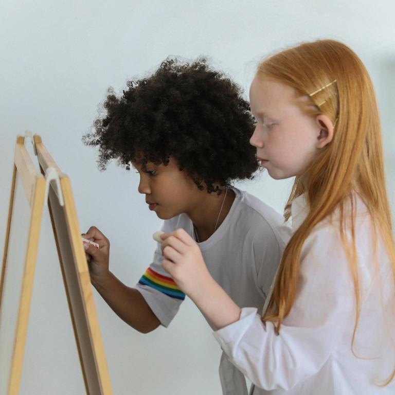 deux filles qui peignent sur un tableau pour un atelier créatif